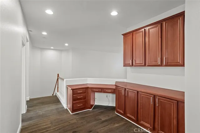 a view of an empty room with wooden floor and window