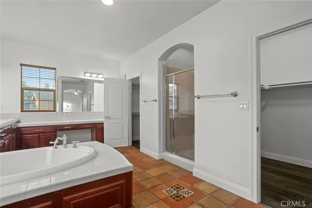 a spacious bathroom with a tub double sink and a large mirror