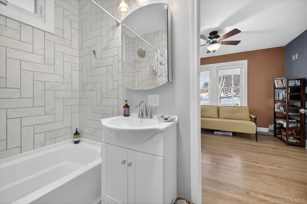 a bathroom with a tub sink and mirror