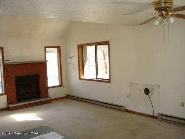2384 Decker Road Bushkill, PA 18324 - Photo 3 of 10 a view of an empty room with a fireplace and a window