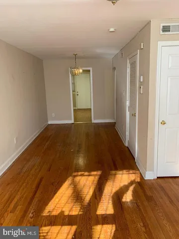 a view of a room with wooden floor chandeliers and kitchen