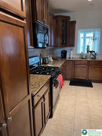 a kitchen with stainless steel appliances granite countertop a stove refrigerator sink and cabinets