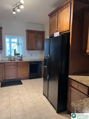 a kitchen with stainless steel appliances granite countertop a refrigerator and a sink