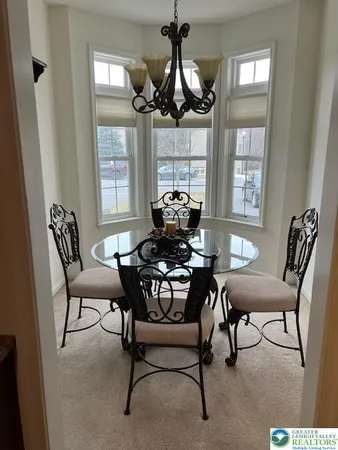 a dining room with furniture a chandelier and window