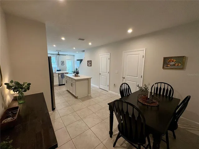 a kitchen with a table chairs a sink and dishwasher