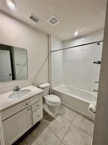 a bathroom with a double vanity sink toilet mirror and bathtub