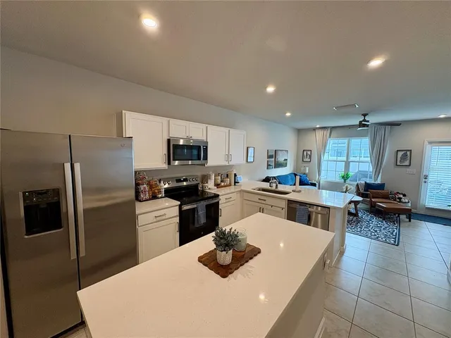 a kitchen with sink refrigerator and microwave
