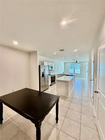 a kitchen with granite countertop a rug a stove a microwave and a counter top space