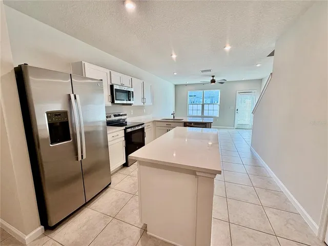 a kitchen with stainless steel appliances granite countertop a refrigerator and a stove