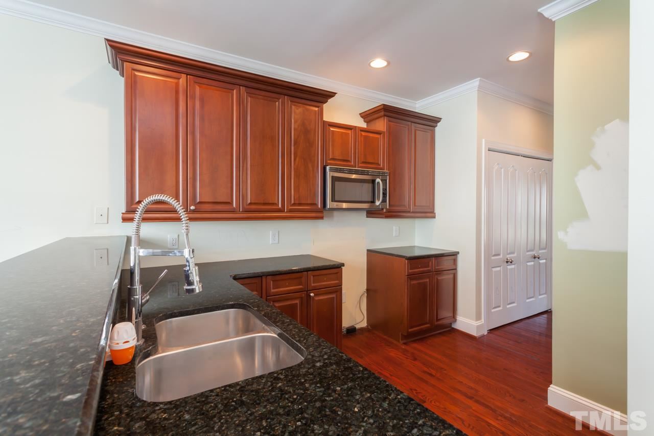 1232 Harp Street Raleigh, NC 27604 - Photo 11 of 25 a kitchen with stainless steel appliances granite countertop a sink a stove cabinets and wooden floor