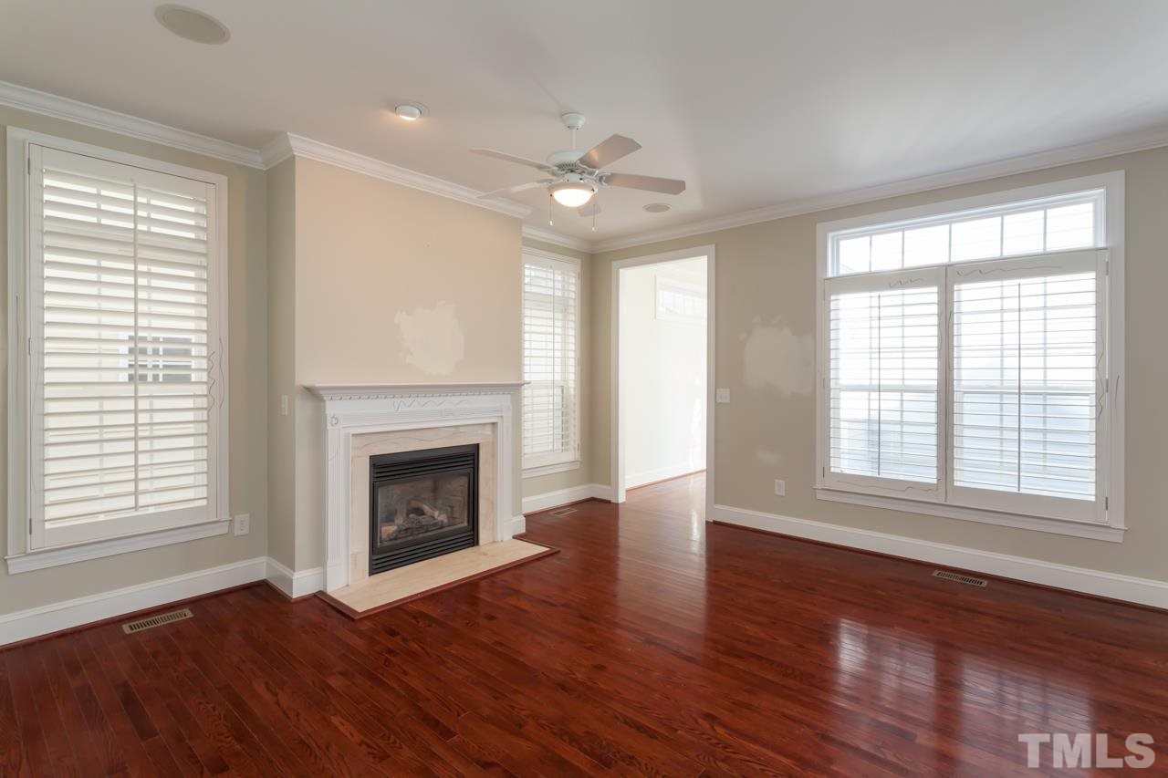 1232 Harp Street Raleigh, NC 27604 - Photo 13 of 25 a view of an empty room with wooden floor fireplace and a window
