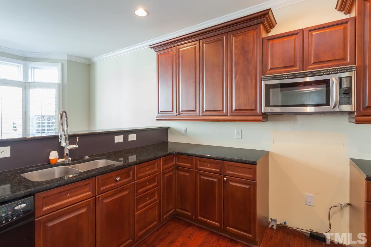 1232 Harp Street Raleigh, NC 27604 - Photo 10 of 25 a kitchen with granite countertop cabinets stainless steel appliances a sink and wooden floor