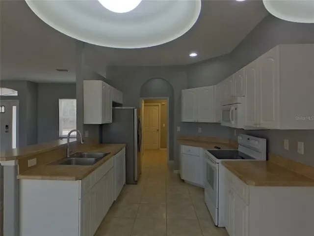a kitchen with granite countertop a sink a stove and refrigerator