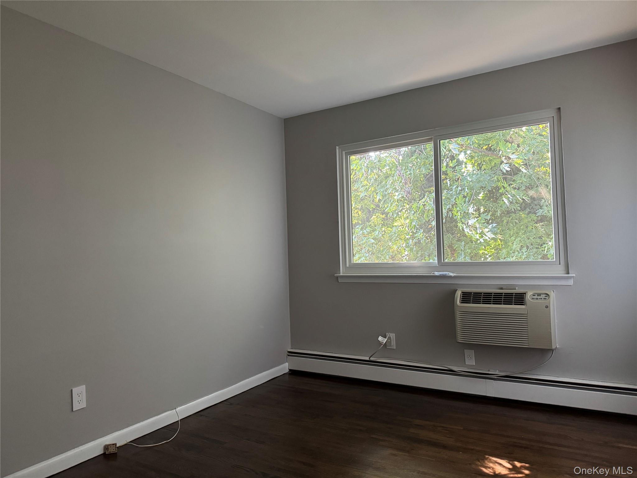 39 B South Norwood Road, Unit RIGHT Port Washington, NY 11050 - Photo 13 of 18 a view of an empty room with wooden floor and a window