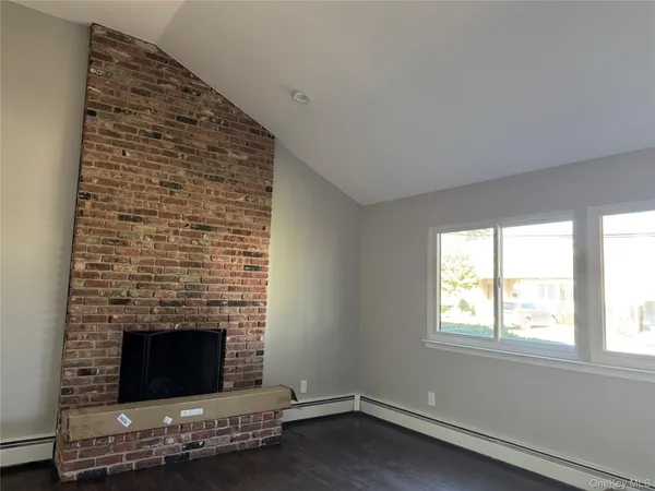 an empty room with a fireplace and window