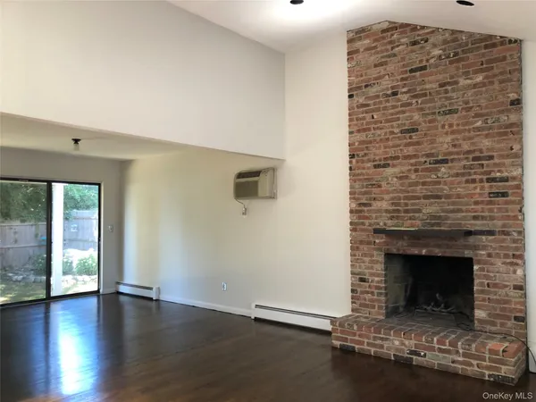a living room with a fireplace and a floor to ceiling window