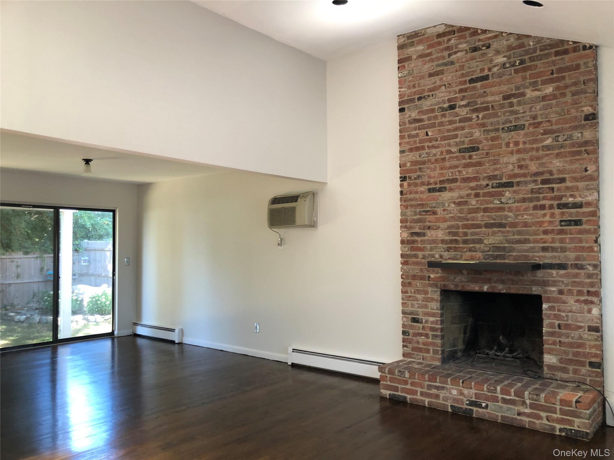 39 B South Norwood Road, Unit RIGHT Port Washington, NY 11050 - Photo 4 of 18 a living room with a fireplace and a floor to ceiling window
