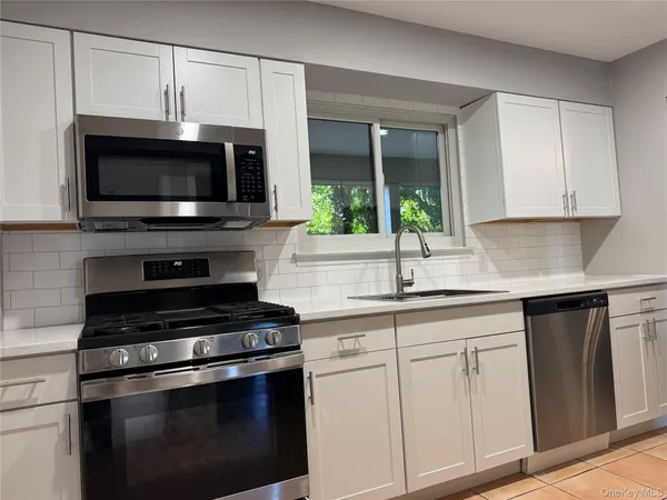 a kitchen with cabinets stainless steel appliances and a sink