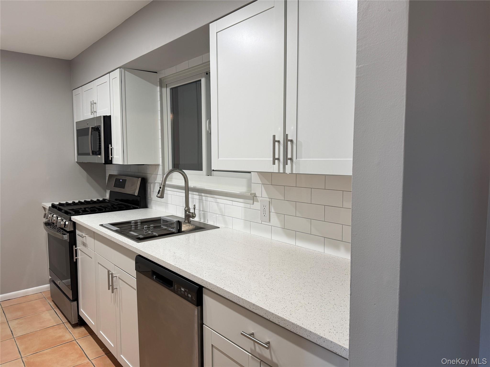 39 B South Norwood Road, Unit RIGHT Port Washington, NY 11050 - Photo 10 of 18 a kitchen with a sink stove and cabinets