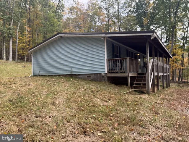 a backyard of a house with barbeque oven and trees