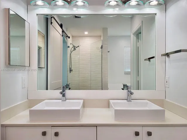 a bathroom with double vanity sinks and a mirror