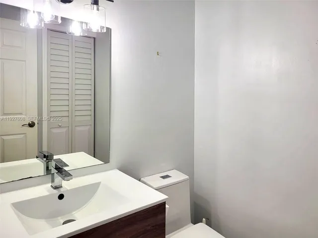 a bathroom with a sink a toilet and a mirror