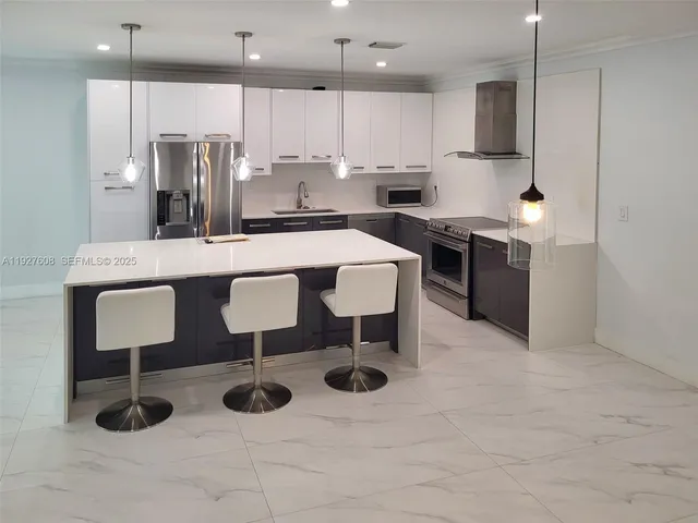 a kitchen with stainless steel appliances granite countertop a sink a stove a refrigerator and cabinets