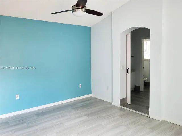 an empty room with closet and a ceiling fan