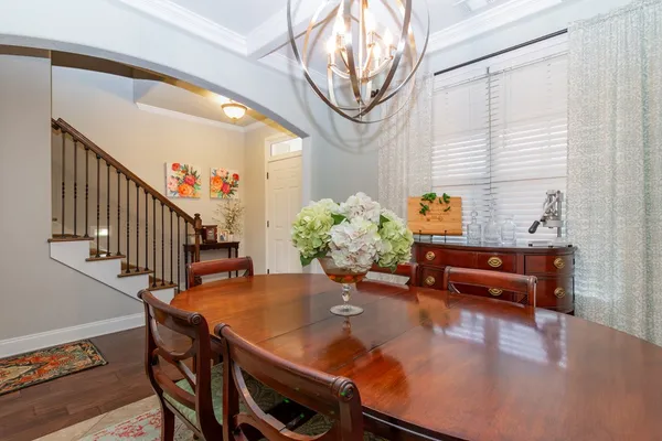 a dining room with furniture a potted plant and wooden floor