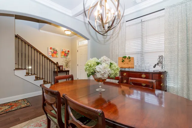 a dining room with furniture a potted plant and wooden floor