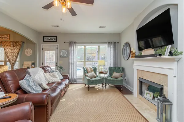 a living room with furniture a flat screen tv and a fireplace