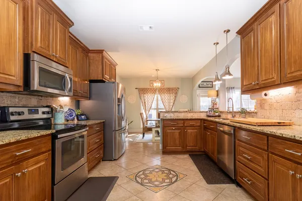 a kitchen with stainless steel appliances granite countertop sink stove top oven and cabinets