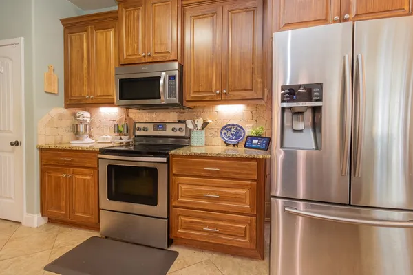 a kitchen with stainless steel appliances granite countertop a refrigerator stove and sink