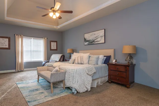 a spacious bedroom with a bed and a chandelier