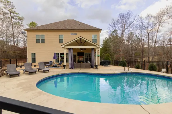 a view of a house with swimming pool and sitting area