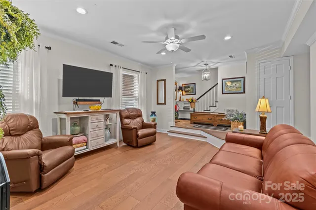 a living room with furniture and a flat screen tv with wooden floor
