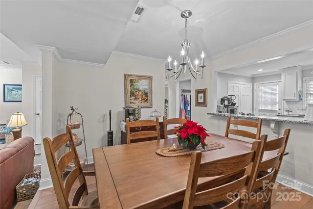 a view of a dining room with furniture and chandelier