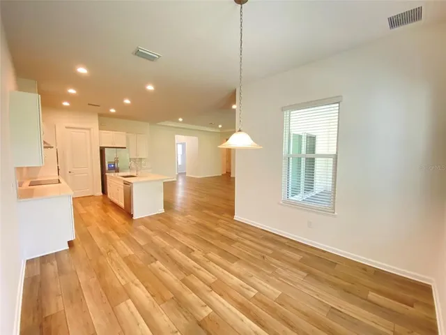 a view of kitchen with kitchen island wooden cabinets and refrigerator