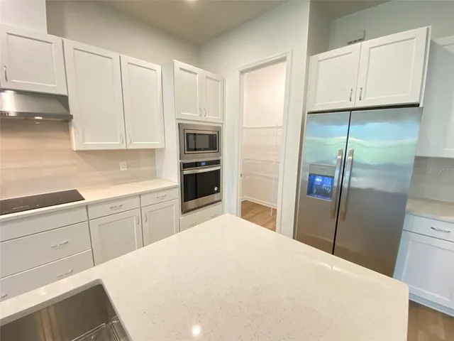 a kitchen with stainless steel appliances a refrigerator sink and cabinets