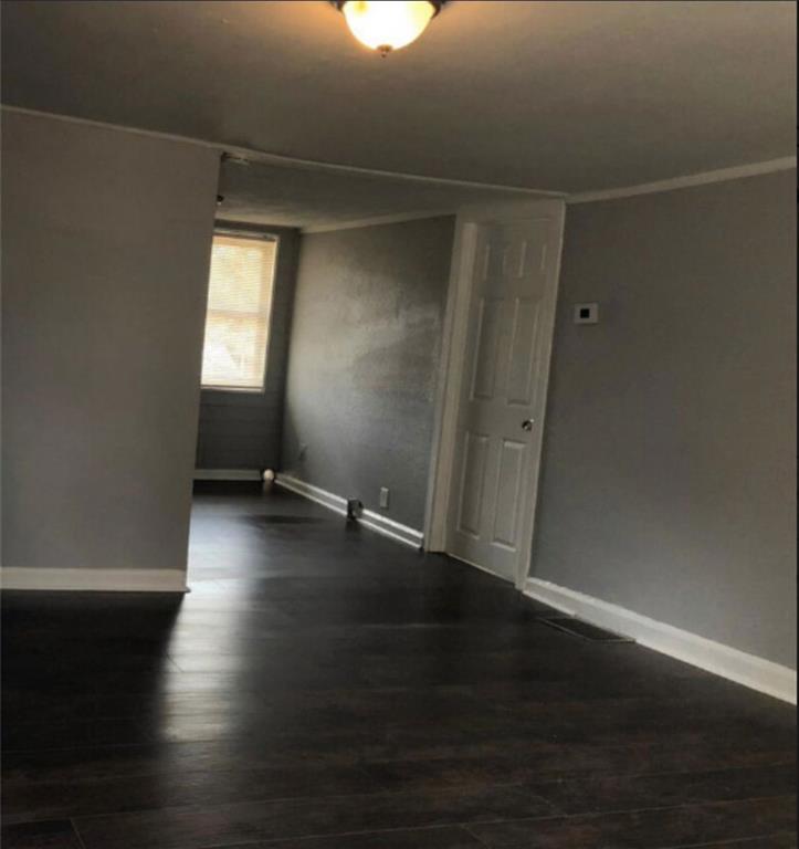 116 Lambert Drive Stockbridge, GA 30281 - Photo 4 of 8 an empty room with wooden floor and windows with curtains