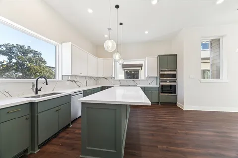 a kitchen with a sink dishwasher a stove and a refrigerator with wooden floor