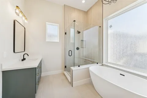 a bathroom with a tub sink shower and mirror