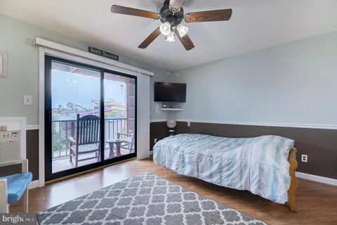 a bedroom with a large bed and a flat tv screen on dresser