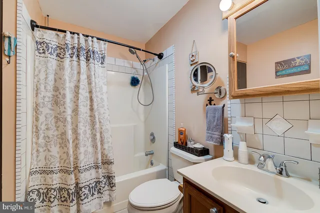 a bathroom with a sink a toilet and shower curtain