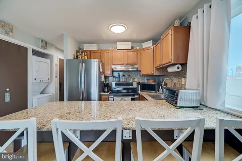 a kitchen with stainless steel appliances granite countertop a stove refrigerator and a refrigerator