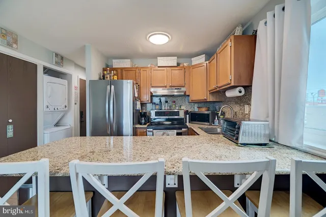a kitchen with stainless steel appliances granite countertop a stove refrigerator and a refrigerator