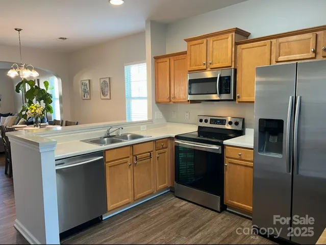 a kitchen with stainless steel appliances granite countertop a sink stove and refrigerator