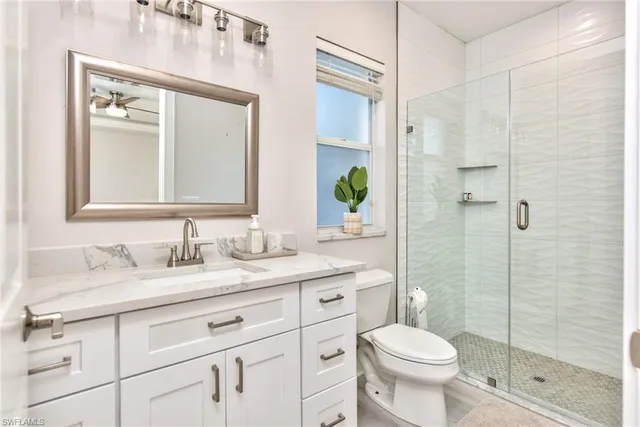 a bathroom with a granite countertop toilet sink and mirror