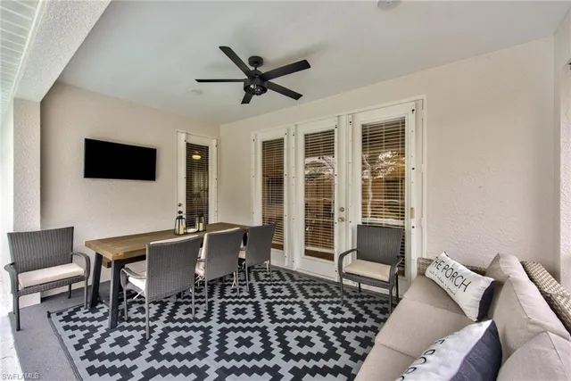 a living room with furniture a flat screen tv and a table