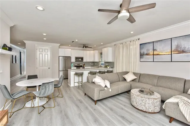 a living room with furniture white walls and kitchen view